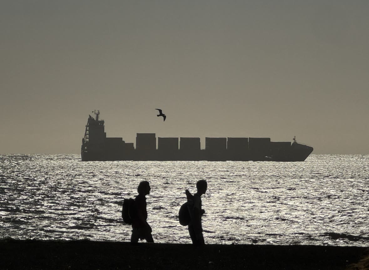 Figures and a ship against the sea